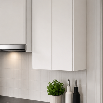 Modern kitchen with white cabinets, a plant, and kitchen utensils.