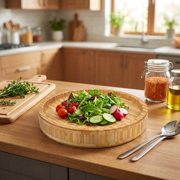 Create a lifestyle scene featuring the bamboo round tray in a modern kitchen setting. View the tray from a slight top-down angle, with the camera at a 45-degree tilt using a 50mm lens, focusing sharply on the textured bamboo surface. The tray is styled wit