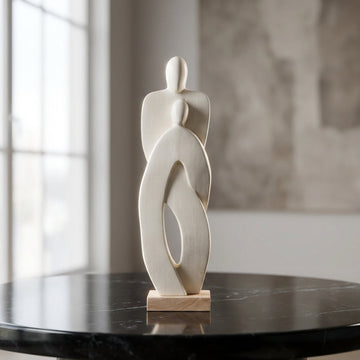 Create a cinematic, high-resolution studio shot of the 'Standing Couple - White' sculpture as a centerpiece on a sleek, reflective black marble table. Use diffused daylight balanced with HDR studio lighting to highlight the smooth, polished wooden texture 