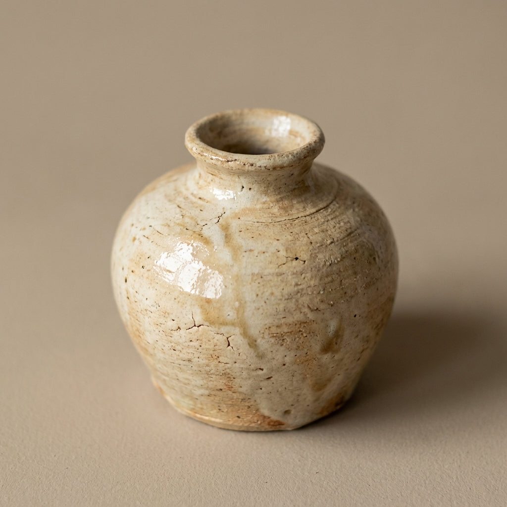A close-up shot of a rustic mini pot meticulously handcrafted by Filipino artisan potters, captured under softbox lighting that highlights the textured, high-quality clay surface. The camera is set at a slight angle with a 50mm focal length, emphasizing th