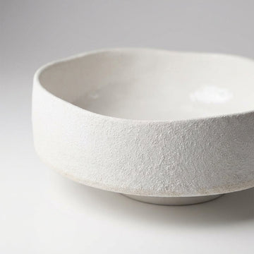 Capture a close-up, studio-shot of the 'Bella Bowl - White' in a minimalistic, high-key environment using softbox lighting to highlight its smooth, glossy white ceramic surface. The image is taken with a Canon EOS 5D Mark IV, 50mm lens at f/2.8, with a sha