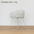 A highly detailed product shot of the Portabello Chair - Fog in a clean, professional studio setting. The chair is illuminated with softbox lighting to emphasize its sleek wire construction and fog-gray finish, creating a soft, diffuse glow on the surface.