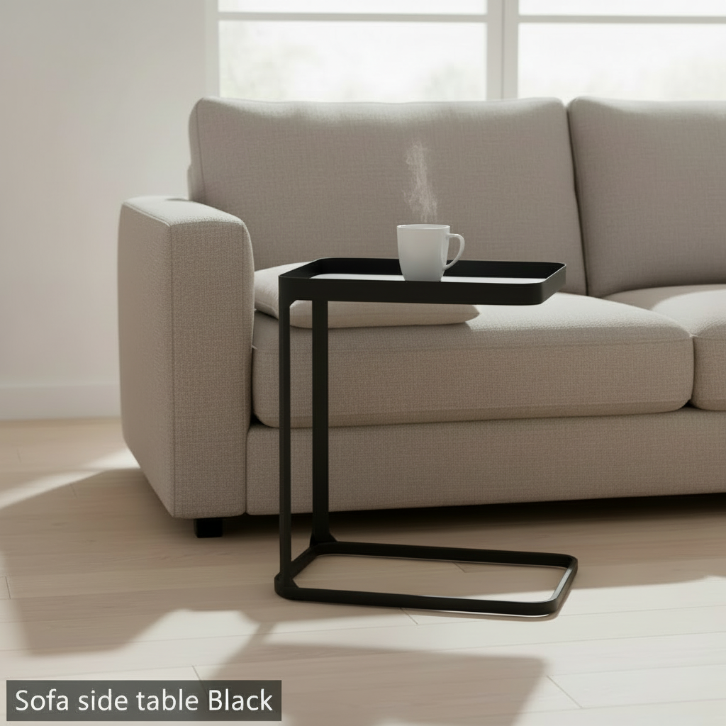 Capture a refined studio shot of the black sofa side table, spotlighted with softbox lighting to emphasize its sleek matte finish and smooth edges. Position the table in the center of a modern, minimalist living room setting with a muted, textured fabric s