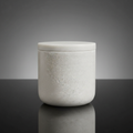 Create a highly detailed, studio-shot image of a 'Marble Cotton Jar' placed on a sleek, reflective black glass surface. Use softbox lighting to evenly illuminate the white marble's natural textures, highlighting the subtle veins and imperfections that emph