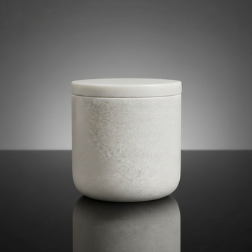 Create a highly detailed, studio-shot image of a 'Marble Cotton Jar' placed on a sleek, reflective black glass surface. Use softbox lighting to evenly illuminate the white marble's natural textures, highlighting the subtle veins and imperfections that emph