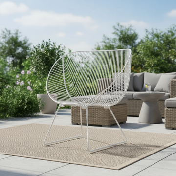 Prompt 2: Create a vivid lifestyle scene featuring the Coromandel Stainless Steel Chair in a bright, airy outdoor patio setting during late morning. The chair is shown from a low-angle shot at a 35mm focal length, emphasizing its sleek contours and the glo
