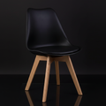 Capture a high-end, studio-shot of the Kris Oak Chair, positioned centrally against a sleek, matte black background, illuminated with softbox lighting to highlight the rich grain and smooth finish of the European Oak. Use a slightly elevated camera angle w