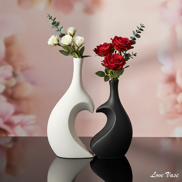 Create a cinematic studio shot of the 'Love Vase' set against a soft, blurred romantic-themed backdrop. Use diffused daylight studio lighting with a gentle fill to highlight the sleek contrast between the black and white halves. Position the vase on a refl