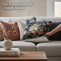 Create a cinematic lifestyle scene showcasing the 'Moody Bloom' Sari Velvet Cushion in a stylish, modern living room. Use diffused daylight balanced HDR studio lighting to cast a warm glow, emphasizing the lush fabric and detailed floral print. Position th