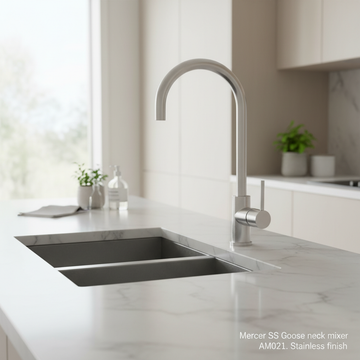 Construct a vibrant lifestyle scene featuring the Mercer SS Goose Neck Mixer AM021 installed on a contemporary kitchen sink, illuminated with diffused daylight to create a warm, inviting atmosphere. Use a slightly wider camera angle with a focus on the sle