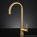 A highly detailed, professional studio shot of the Mercer SS Gooseneck Mixer AM027 Brass, captured with a macro lens at 100mm focal length to emphasize the intricate brass finish. The lighting setup includes softbox diffused daylight to highlight the warm,