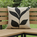 A luxurious, studio-shot composition of the 'Cushion Prints - Leaf' displayed on a stylish outdoor patio bench. The scene employs HDR studio lighting with diffused daylight to accentuate the vibrant leaf print on the cushion’s fabric, emphasizing its textu