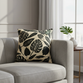Capture a luxurious living room scene featuring the 'Cushion Prints - Leaves' prominently displayed on a modern, plush sofa. Use softbox lighting with a slight HDR effect to highlight the vibrant leaf print's intricate details and rich colors. The camera i