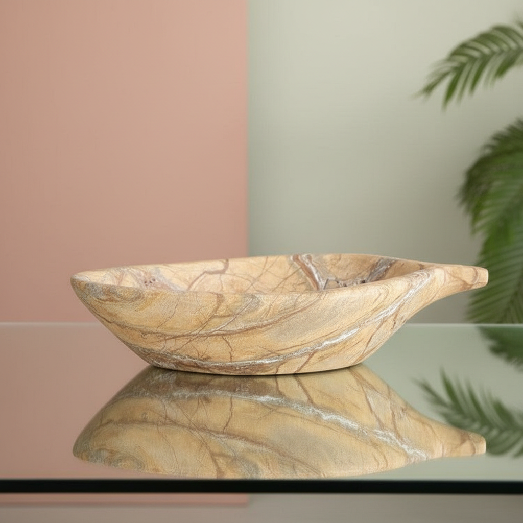 Create a highly detailed, studio-grade image of a 'Marble Stone leaf Bowl' positioned centrally on a sleek, reflective glass surface in a modern, minimalist environment. Use softbox lighting to emphasize the natural veining and smooth texture of the white 