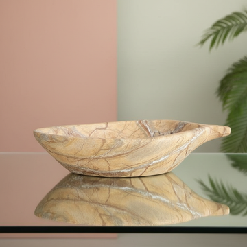 Create a highly detailed, studio-grade image of a 'Marble Stone leaf Bowl' positioned centrally on a sleek, reflective glass surface in a modern, minimalist environment. Use softbox lighting to emphasize the natural veining and smooth texture of the white 