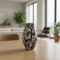 Create an artistic, lifestyle-style composition featuring the Tear Drop Vase placed on a polished wooden table in a bright, airy living room with natural daylight streaming through large windows. Use a macro lens to focus sharply on the vase, capturing the