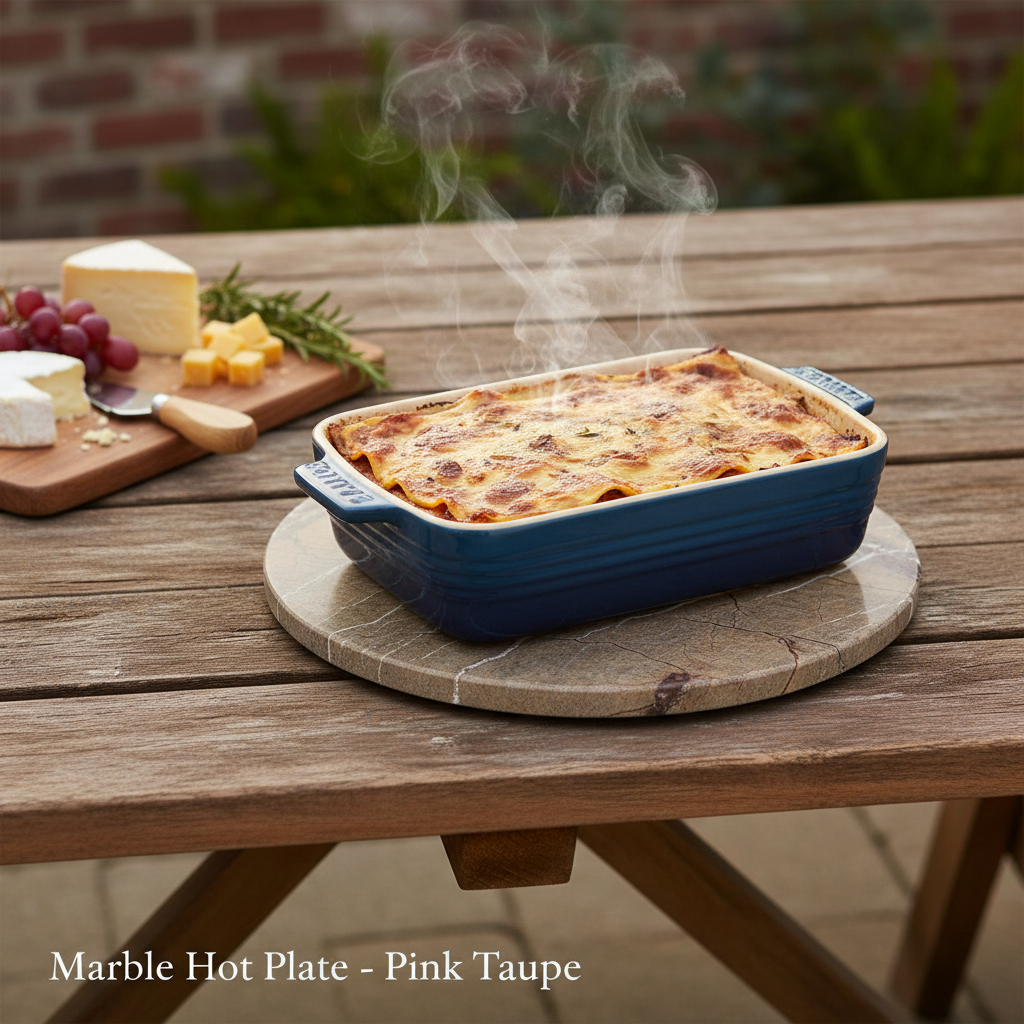 A lifestyle scene featuring the Marble Hot Plate - Pink Taupe, styled on a rustic outdoor wooden table under diffused daylight that enhances the warm pink taupe tones and marble veining. The hot plate is placed beneath a baking dish with steaming contents,